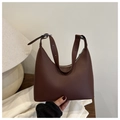Close-up of a dark brown matte leather baguette bag with silver zipper and adjustable strap - Brown