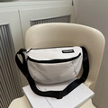 Minimalist white nylon crossbody chest bag with fashion label on a modern cream chair - White