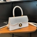 White leather handbag with silver glitter flap and gold rotary buckle for elegant daily use - White