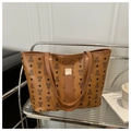 Detailansicht der braunen Leder-Tote-Bag mit Bärenmuster auf einem Metallregal - Braun