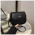 Detail of black leather saddle bag featuring houndstooth texture and golden twist lock - Black