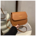 Detail of a brown leather saddle bag with wave embossed texture and adjustable shoulder strap - Brown