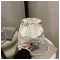 Detail of white bucket bag featuring floral textures, 3D butterflies, and pearl strap - White