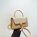 Khaki embroidered tote bag with gold hardware and adjustable strap shown by a model - Khaki