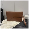 Detailed view of brown envelope bag featuring unique wavy flap and matching wristlet strap - Brown