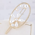 Dettaglio di un fermaglio dorato francese con fiori di perle e texture in metallo intrecciato - Stile Ovale (110307246)