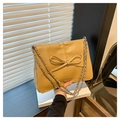 Detail of yellow PU leather shoulder bag featuring pleated texture and large bow detail - Khaki