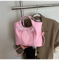 Détail du sac à main rose avec un nœud en dentelle blanche et une bandoulière réglable - Rose