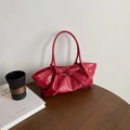 Elegant red bow handbag with pleated leather texture for women on a wooden table - Red