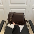 Deep brown matte leather crossbody bag with curved base and gold hardware detailing - Brown