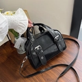 Borsa Boston nera lucida minimalista su tavolo in legno con dettagli in metallo argento - Nero