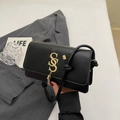 Minimalist black leather crossbody bag with gold logo, tassel detail and knotted strap - Black