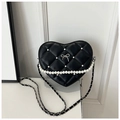 Detail of heart-shaped quilted bag with pearl embellishments and metal bow buckle - Black