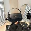 Borsa a sella nera con paillettes e dettagli dorati in una posa a mano elegante - Nero
