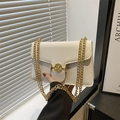 White shoulder bag with embossed floral patterns and gold chain straps - White