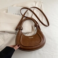 Brown leather crescent crossbody bag with decorative handle knot and fashion lettering - Brown