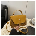 Detalle del bolso amarillo con estampados de monogramas marrones y herrajes dorados - Marrón
