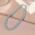 Macro shot of light blue pearl necklace with silver lobster clasp on silk fabric - 10mm / Blue