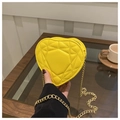 Detalle de bolso amarillo en forma de corazón con acolchado geométrico y cadena dorada - Amarillo