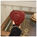 Primer plano detallado de un bolso rojo acolchado con forma de corazón y cadena oro - Rojo