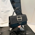 Fashionable black handbag with sequined flap and gold buckle on a stylish leather background - Black