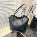 Chic black tote bag in synthetic leather with curved top and vertical stitching - Black