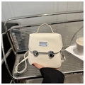 Dettaglio borsa a tracolla in pelle beige con chiusure girevoli argento e manico corto - Bianco Sporco