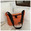Dettaglio borsa a tracolla in nylon arancione con cerniere nere ed etichetta moda su divano - Arancione