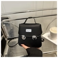Dettaglio di una mini borsa in pelle PU opaca nera con fibbie argentate e logo in metallo - Nero