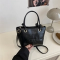 Mini borsa a secchiello vintage nera lucida con logo a rilievo e anelli metallici dorati - Nero