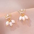 Orecchini a corona dorati con perle barocche naturali su sfondo di raso elegante - Orecchini di Perle d'Acqua Dolce Corona / Oro