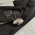 Silberne Mini-Tasche in Muschelform mit Schlangenkette auf einem schwarzen Blazer - Silber