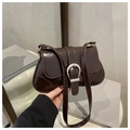 Detail view of a vintage dark brown patent leather underarm bag with silver buckle - Brown