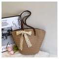 Detail of woven straw tote bag featuring creamy lace bow and durable brown leather handles - With Lace Pendant / Khaki