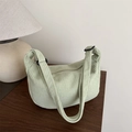 Sac bandoulière demi-lune en velours côtelé vert menthe sur une table en bois - Vert