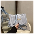 Detailed close-up of light blue shoulder bag featuring textured crinkle material and gold buckle - Blue