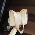 Minimalistische weiße weiche Leder-Einkaufstasche mit breitem Gurt auf Holztreppe - Gebrochenes Weiß