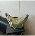 Detailed close-up of green nylon crescent bag with woven strap and knot zipper puller - Green