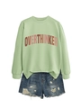 Close-up of mint green crewneck sweatshirt with Overthinker letter print and frayed denim shorts - Olive Green