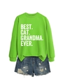 Flat lay of bright green Best Cat Grandma Ever sweatshirt and blue distressed denim shorts - Fluorescent Green (White Print)