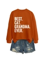 Detail of Best Cat Grandma Ever sweatshirt in orange paired with ripped denim shorts - Burnt Orange (White Print)