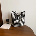 Minimalistische schwarz-weiß gestreifte Tote-Bag mit Logo auf Holzoberfläche - Schwarz Seite A (Gestreift)