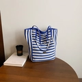 Blue and white striped canvas tote bag with woven handles and metal brand logo - Blue Side A (Striped)