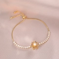 Detail of adjustable gold bracelet featuring purple petals and a central white pearl - Purple Gold Daisy Bracelet