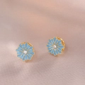 Macro shot of blue daisy stud earrings with gold plating and zircon center on soft fabric - E1145 - Gold Blue