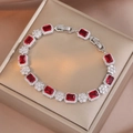 Detail of silver bracelet with red emerald-cut stones and white cubic zirconia on gold box - Deep Red (TS0303)