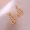 Elegante goldene Herzohrringe mit glitzernden Diamanten auf rosa Textilhintergrund - Herz-Stil (E1183) / Gold
