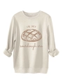 Detailopname van de zuurdesembrood-print en letters op een beige sweatshirt-stof - S / Zandkleur