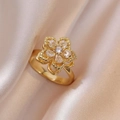 Close-up of a golden flower-shaped ring with marquise and round zircon petals on satin - White Bauhinia Ring