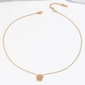 Detail van gouden ketting met een roze zirkoon bloemenhanger op witte zijde stof - Roze vijfbladige bloem ketting (T0231)